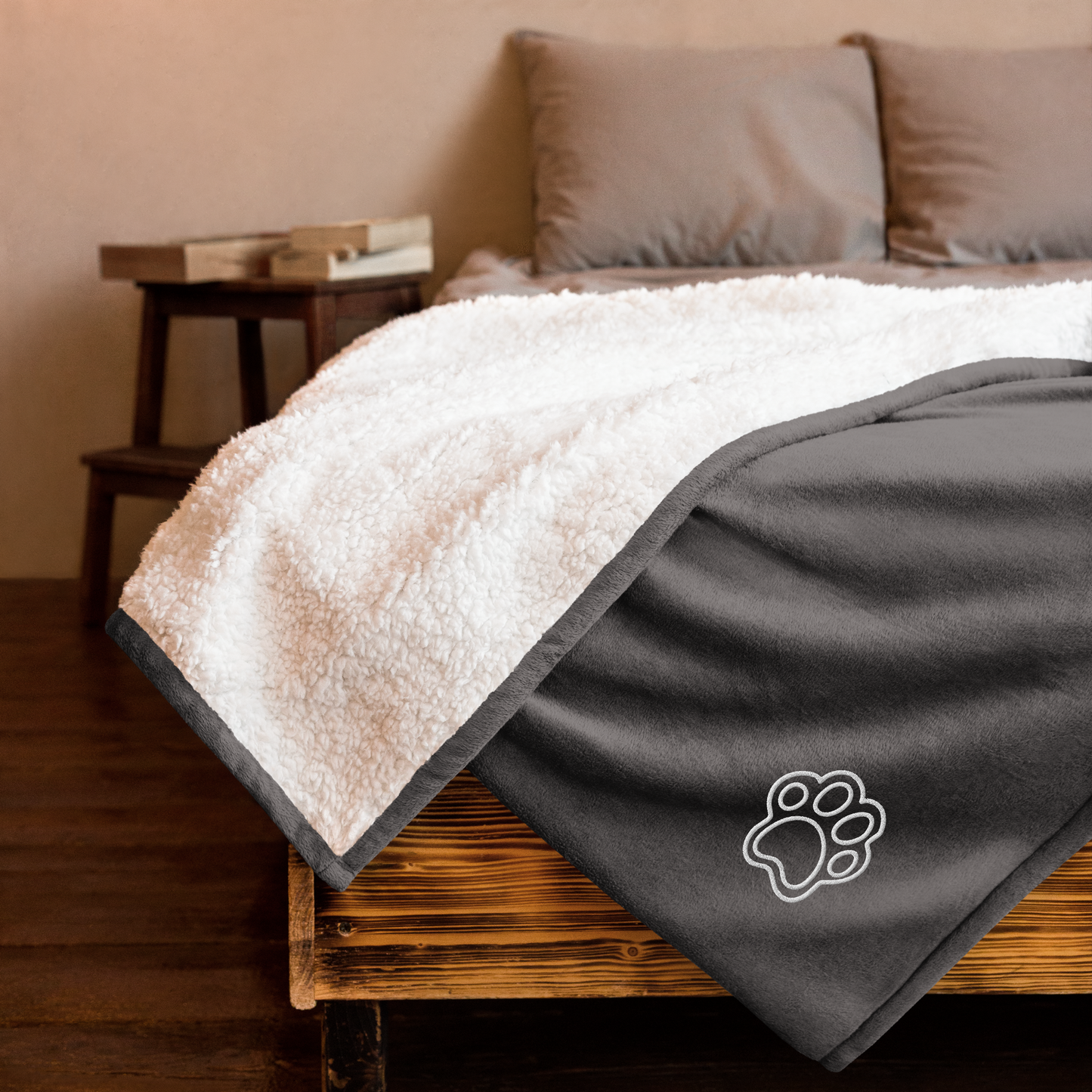 Gray and white blanket with a paw print on a bed - heather grey