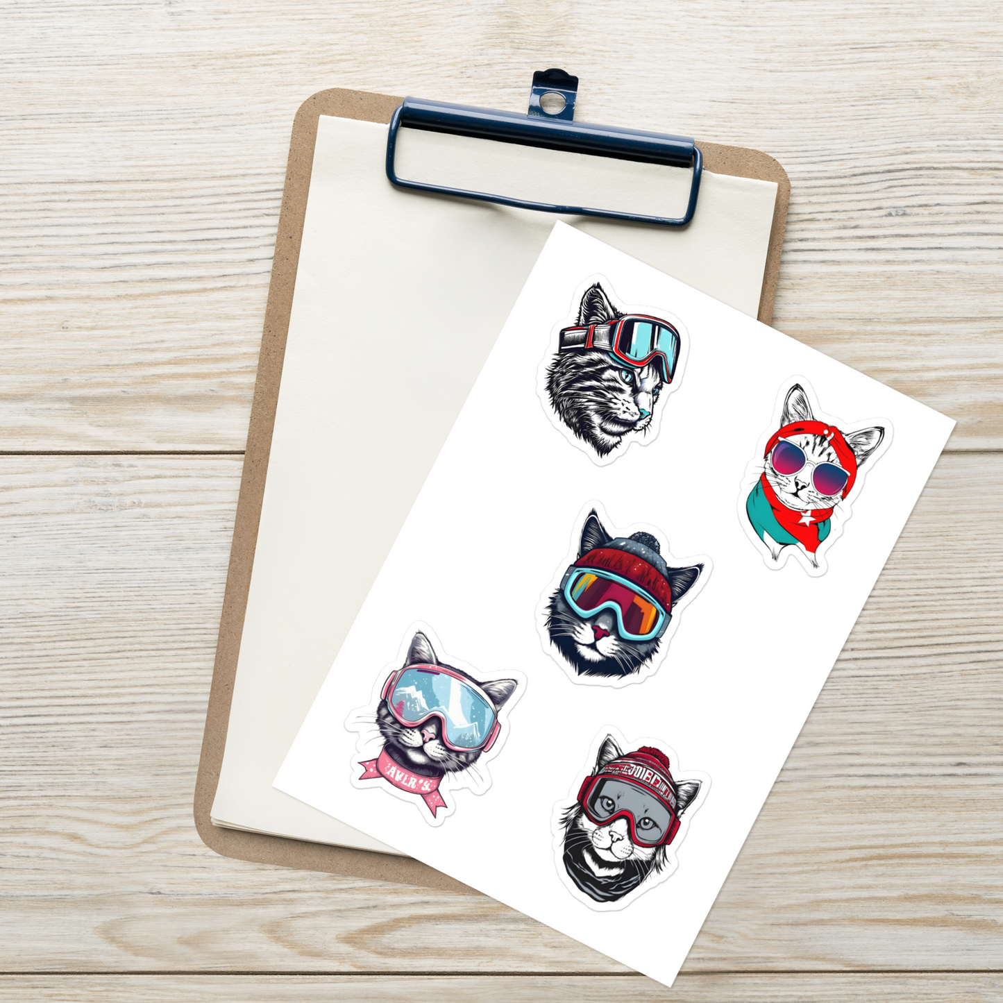 Sheet of temporary tattoos with cat designs wearing sunglasses and hats on a clipboard.