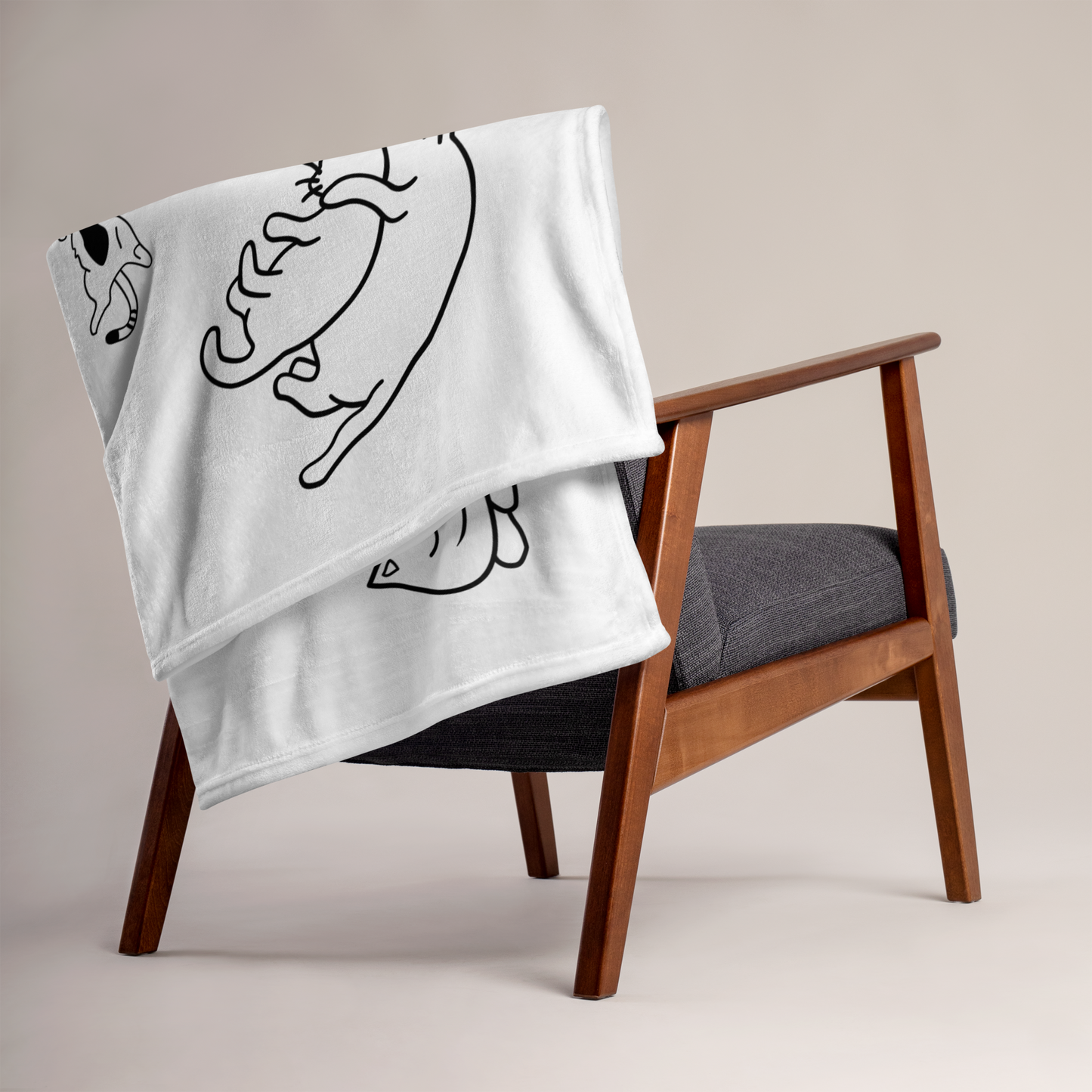 White blanket with black abstract designs draped over a wooden chair with a gray cushion. - all