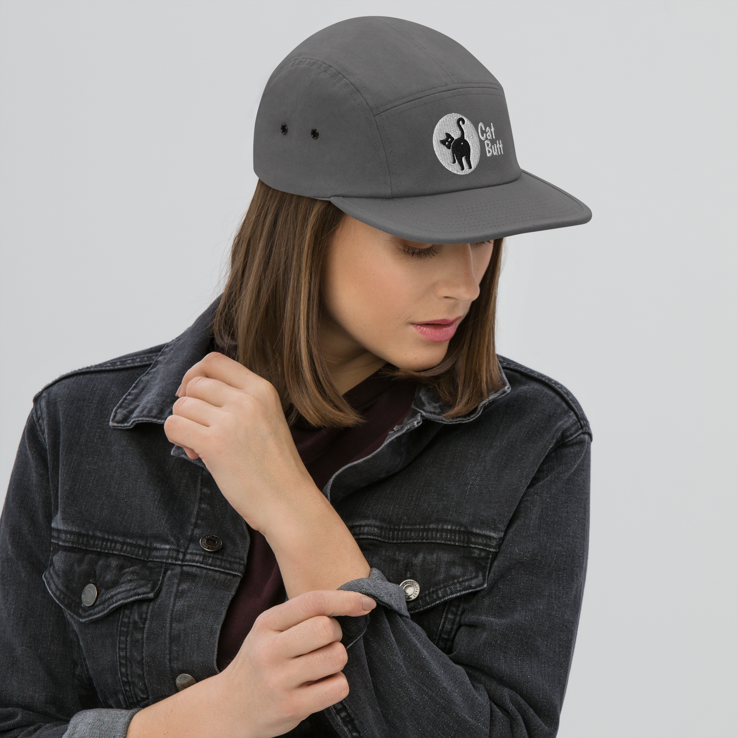 Person wearing a gray cap with a logo on a plain background - grey
