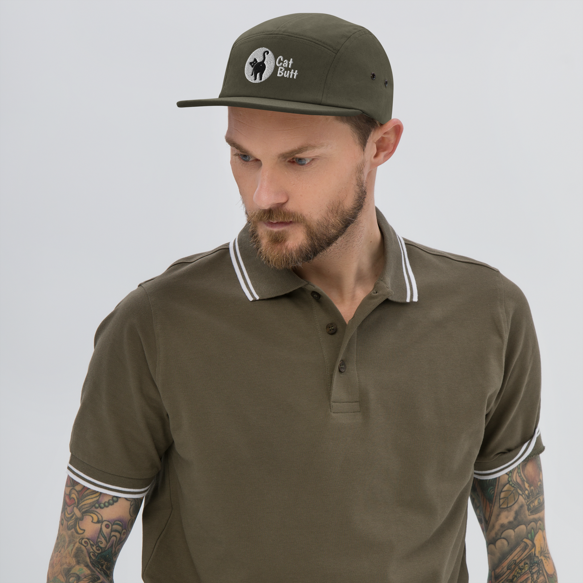 Man wearing a green cap and matching polo shirt on a gray background - olive