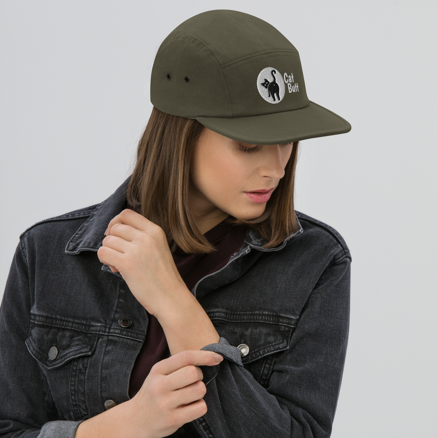 Person wearing a green cap with a logo on a plain background - olive