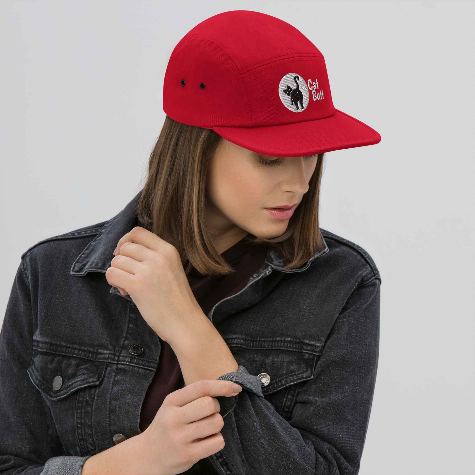 Person wearing a red cap with a logo on a plain background - red