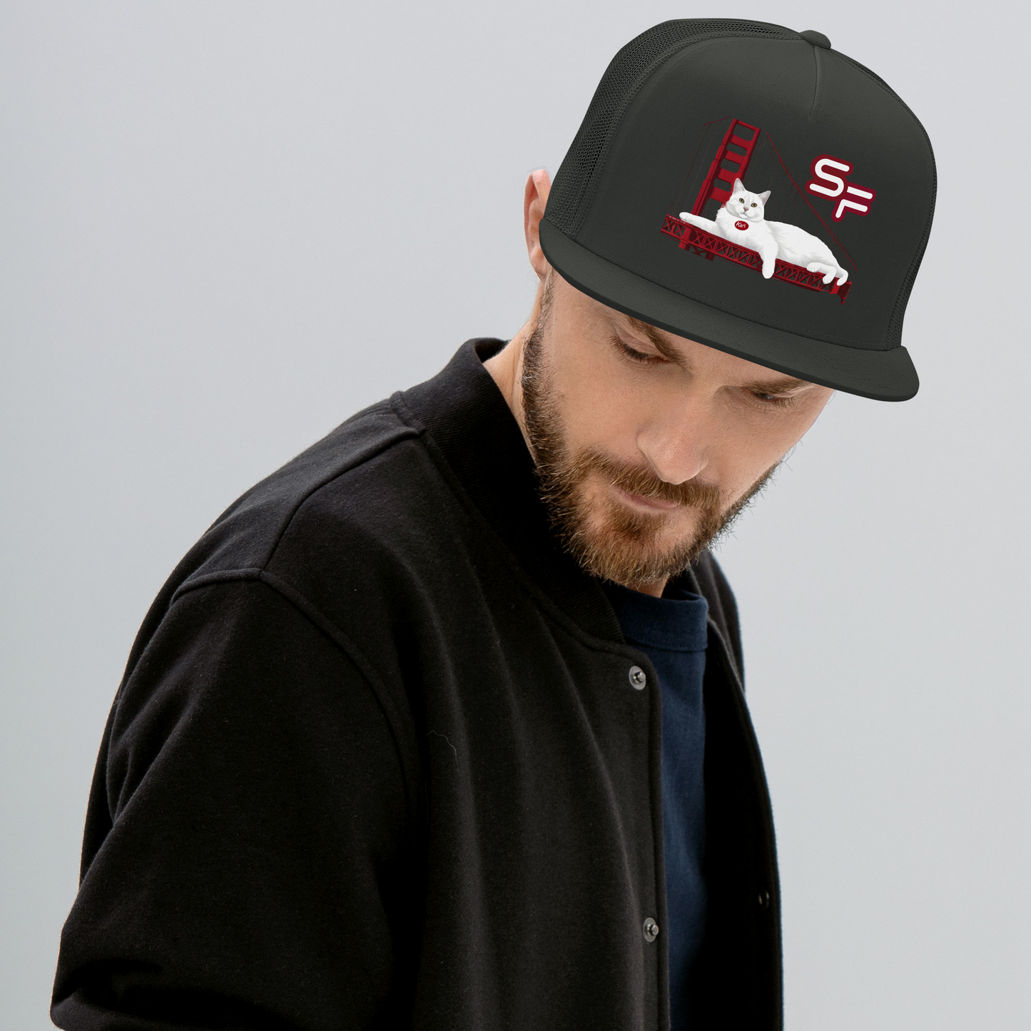 Man wearing a black cap with a logo on a gray background