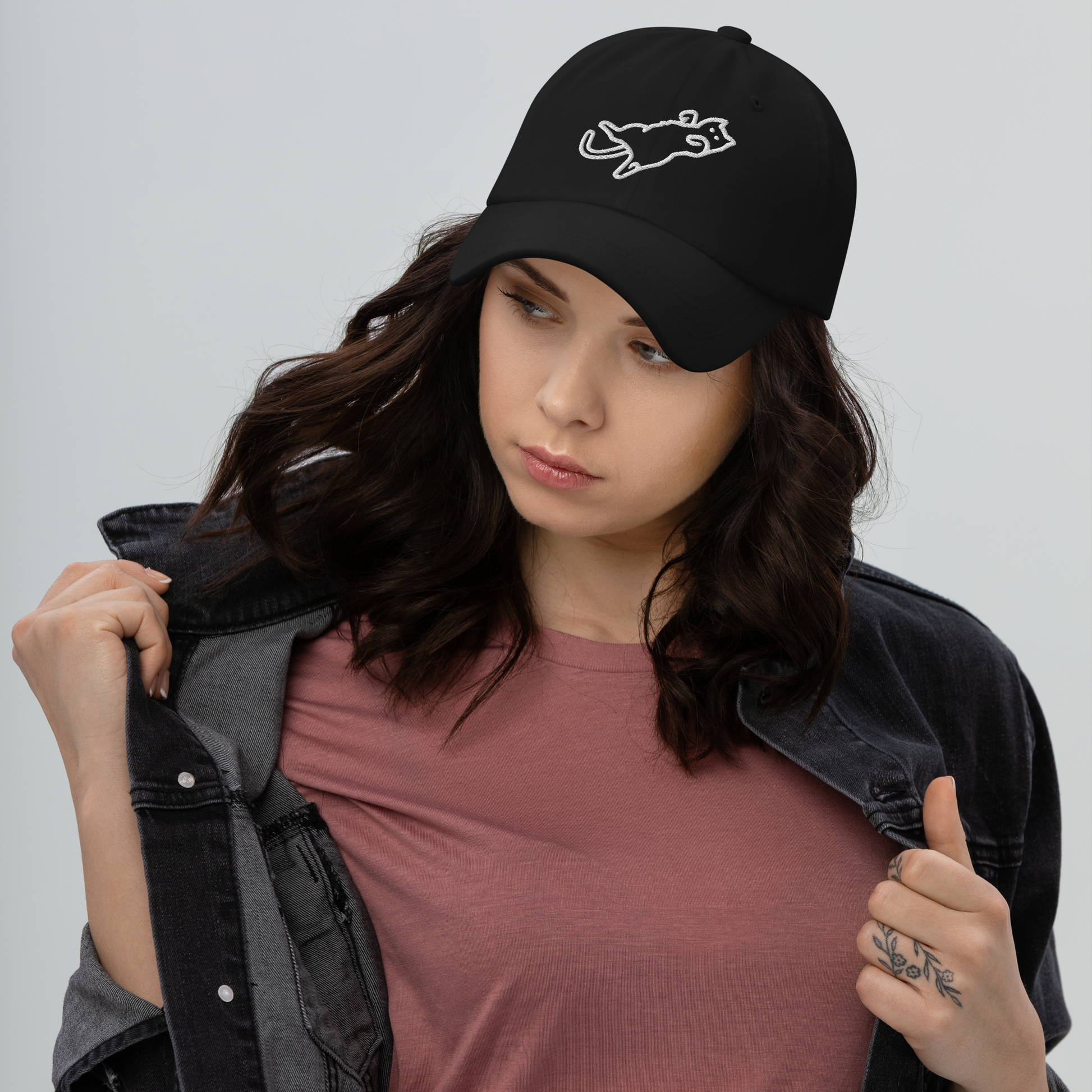 Woman wearing a black cap with a logo on a gray background - black
