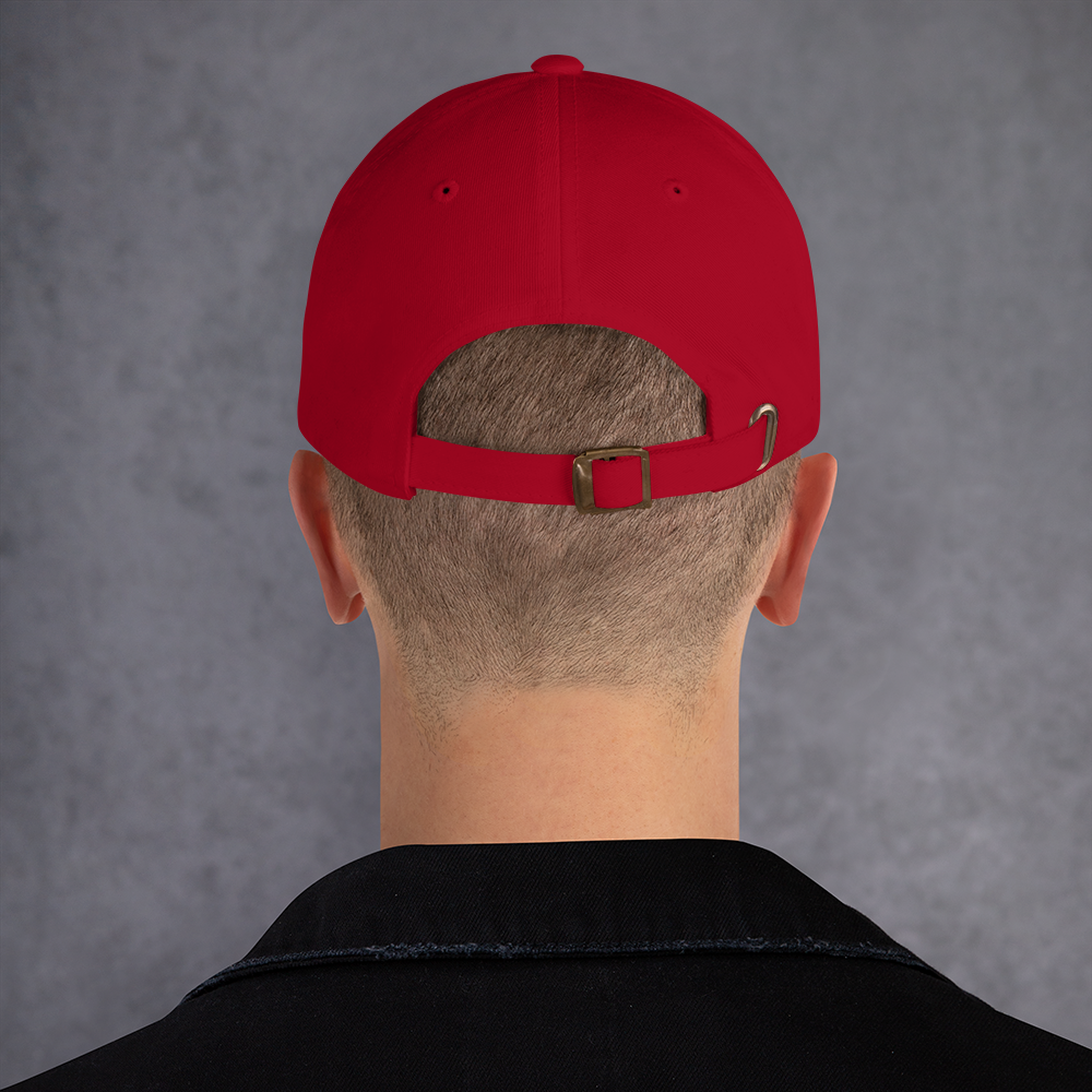Red cap worn backwards on a person against a gray background - cranberry