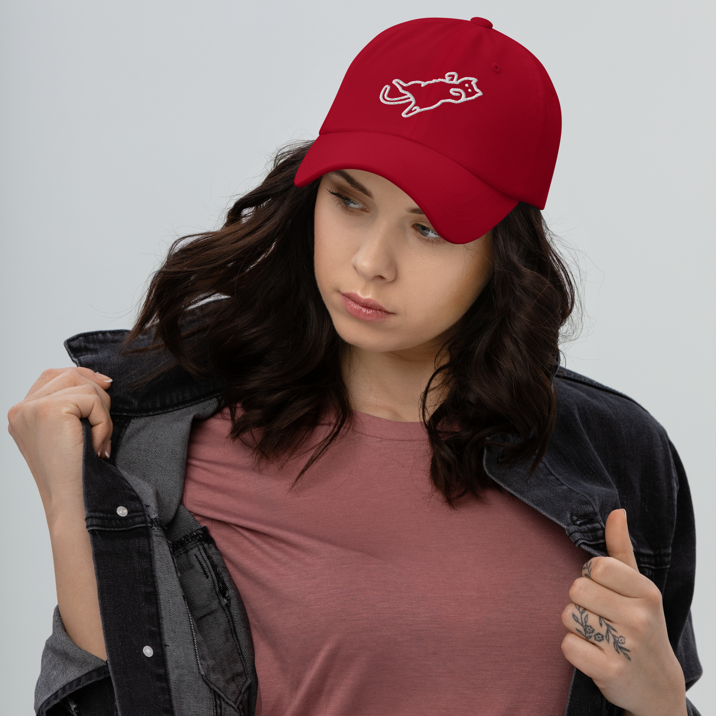 Woman wearing a red cap with a logo on a plain background - cranberry