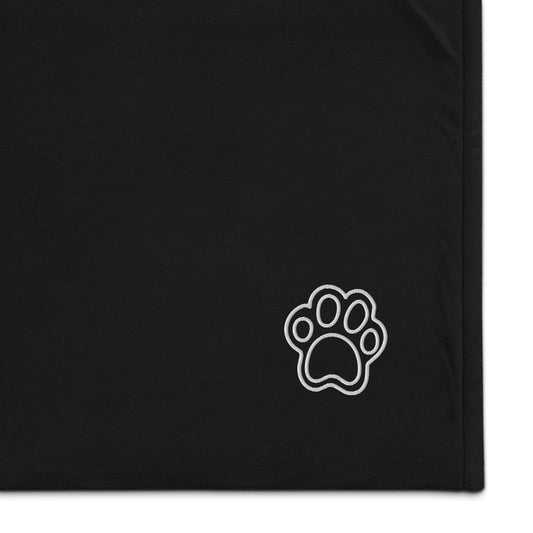 The corner of a sherpa blanket with a cute cat paw embroidered onto it - Black