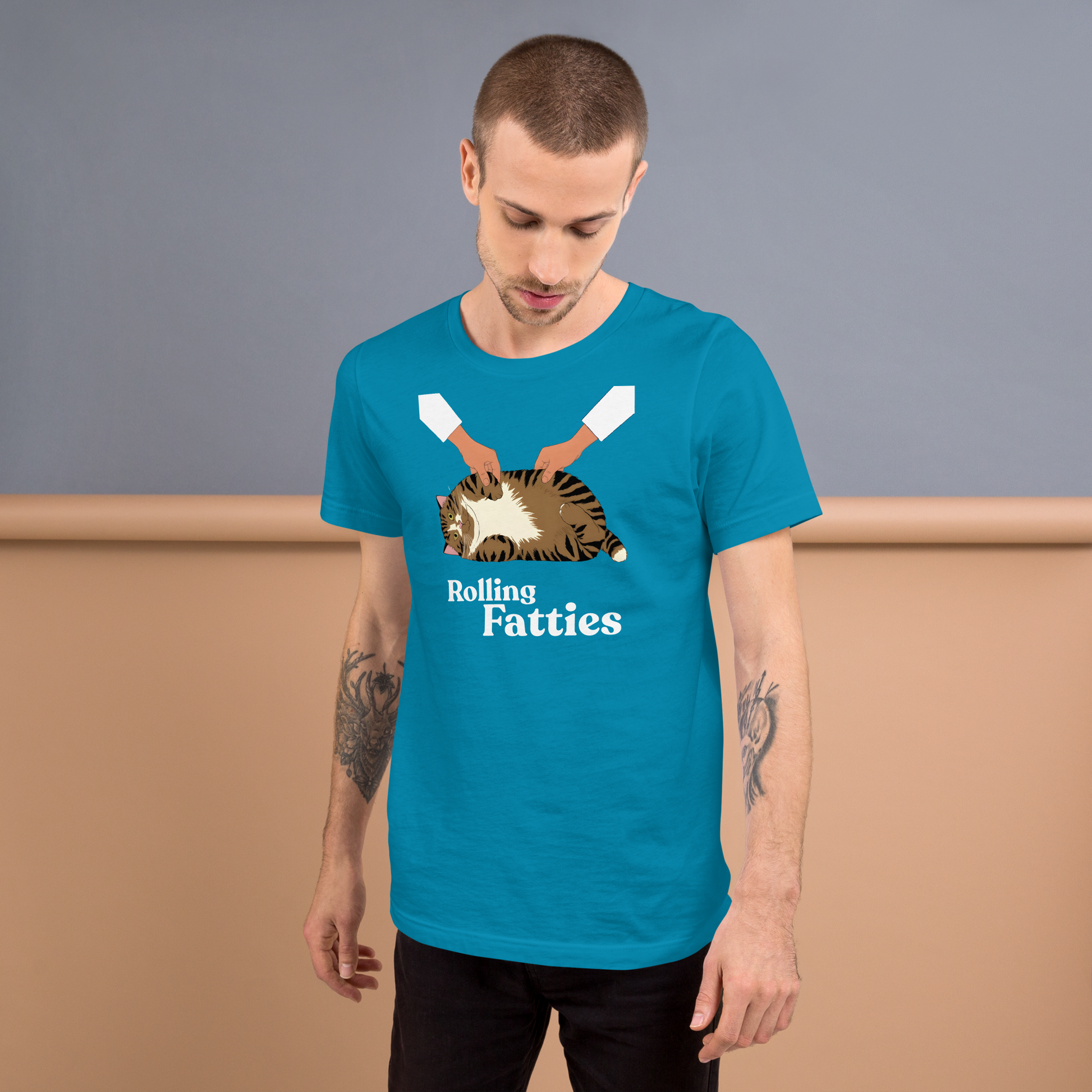 Man wearing a blue t-shirt with a graphic design and text, standing against a plain background. - aqua