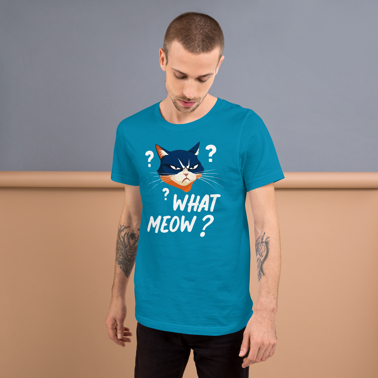 Man wearing a blue t-shirt with a cat graphic and text, standing against a plain background - aqua