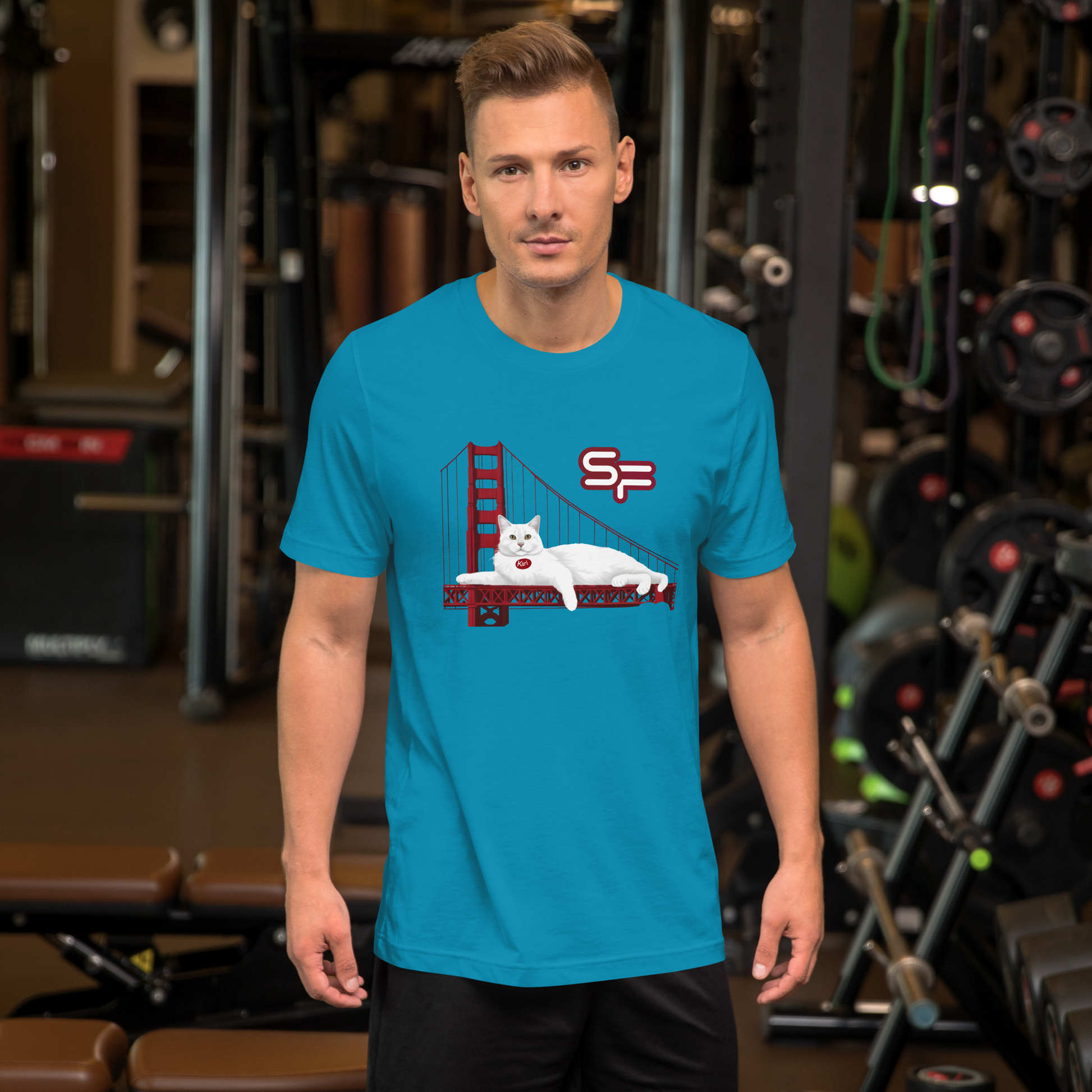Man wearing a blue t-shirt with a graphic design in a gym setting - aqua
