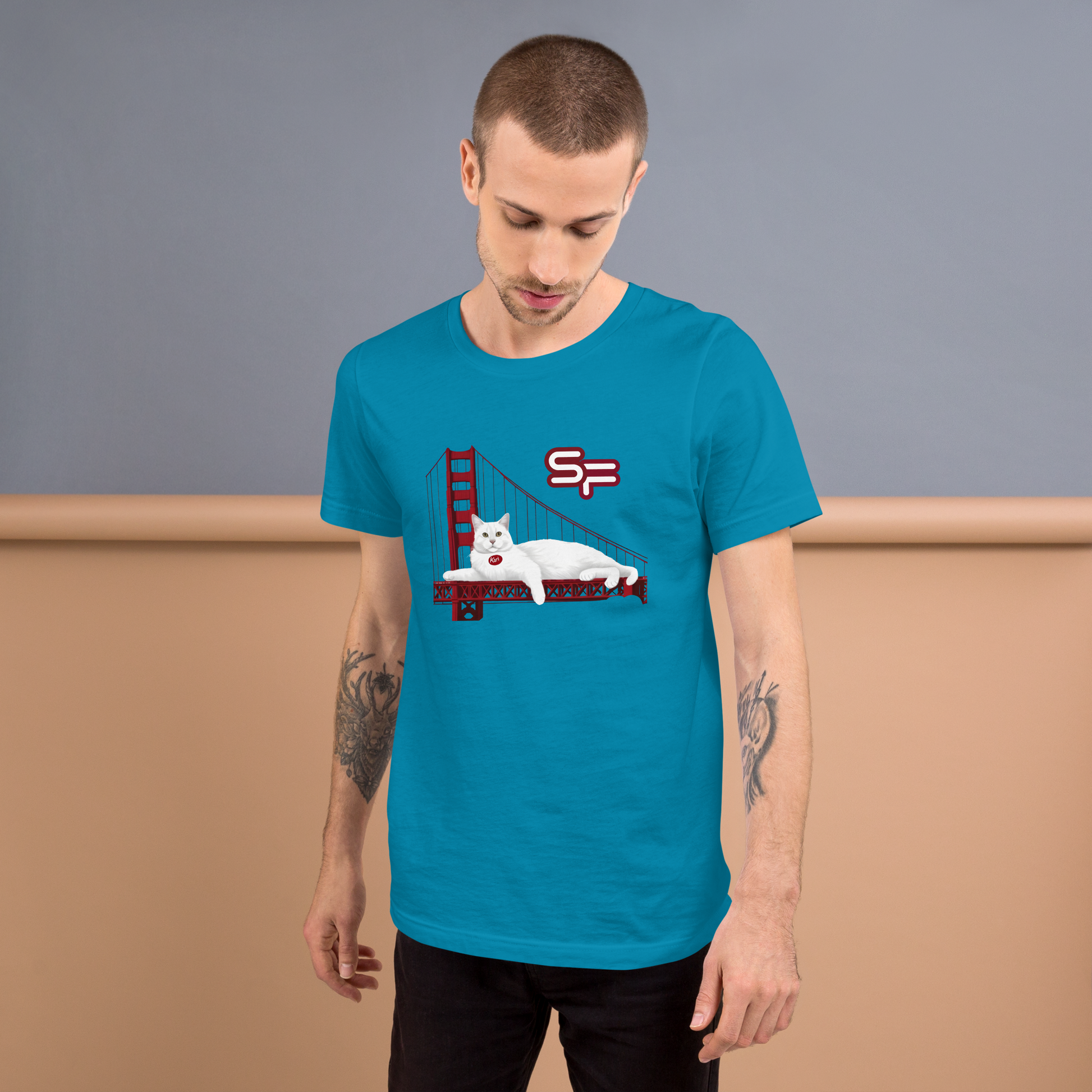 Man wearing a blue t-shirt with a graphic design of a cat on a leash with a flag, standing against a plain background. - aqua