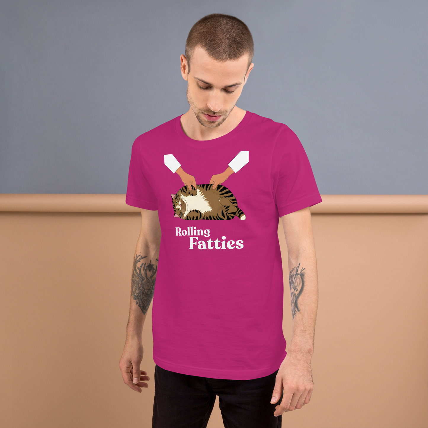 Man wearing a pink t-shirt with a graphic design and text, standing against a plain background. - berry