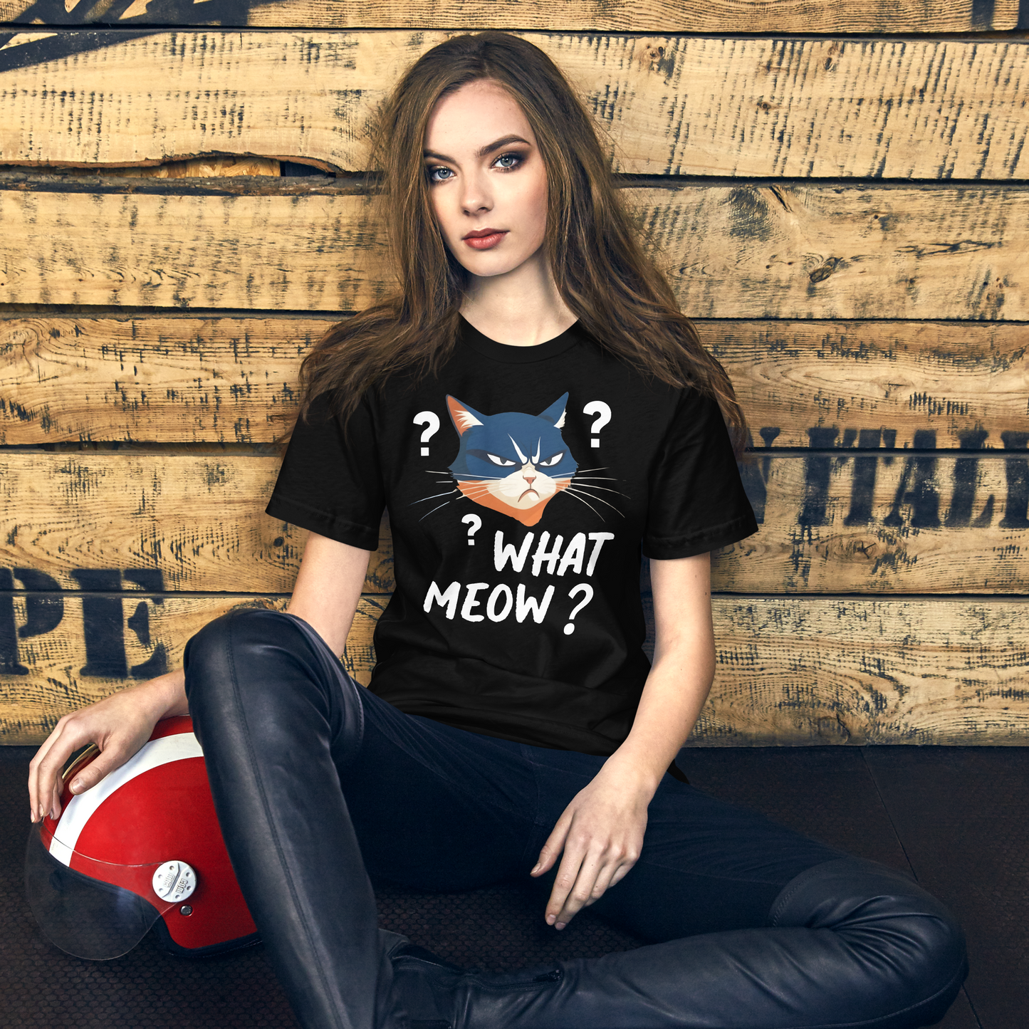 Woman wearing a black t-shirt with a cat graphic and text, sitting against a wooden wall. - black