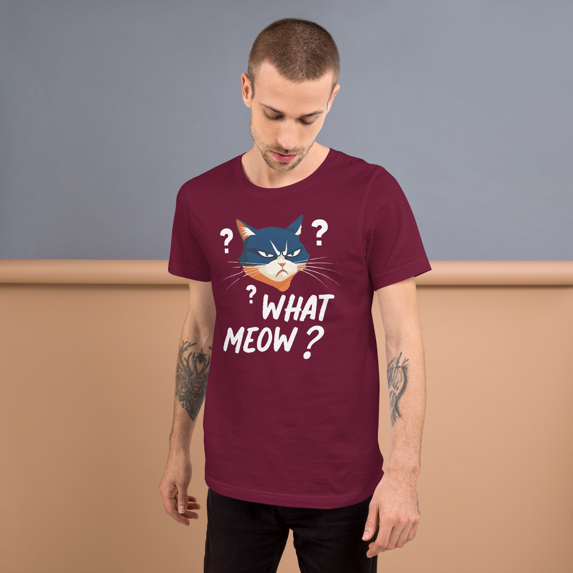 Man wearing a maroon t-shirt with a cat graphic and text, standing against a plain background. - maroon