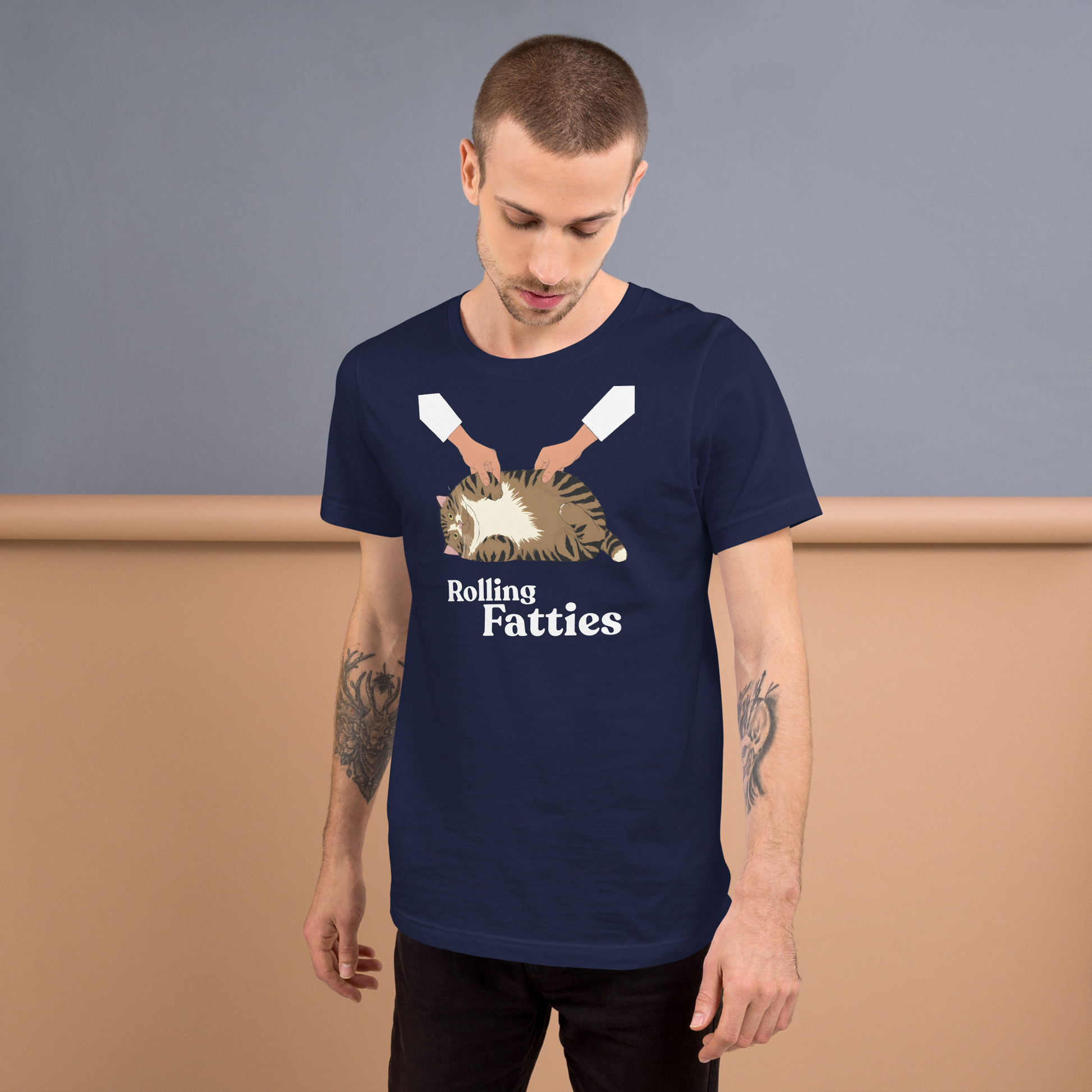 Man wearing a navy blue t-shirt with 'Rolling Fatties' graphic design against a gray and brown background - navy