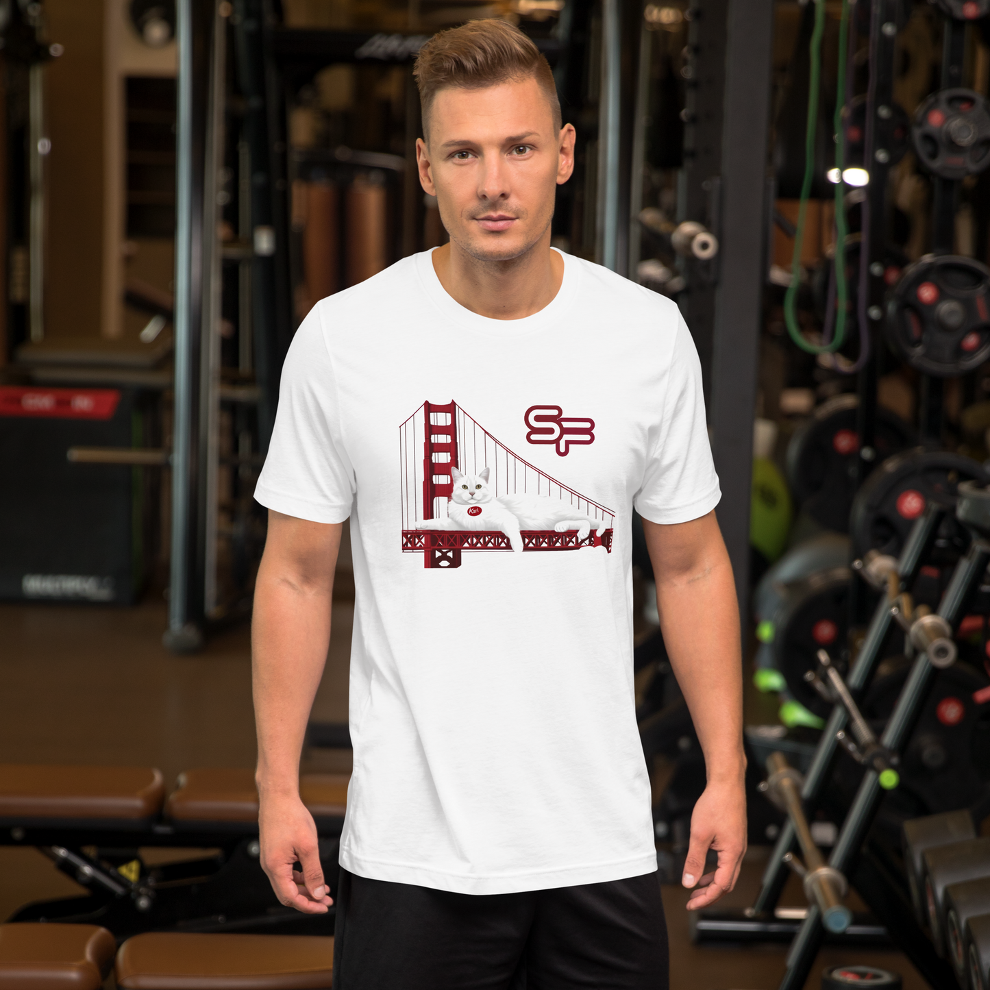 Man wearing a white t-shirt with a graphic design in a gym setting - white