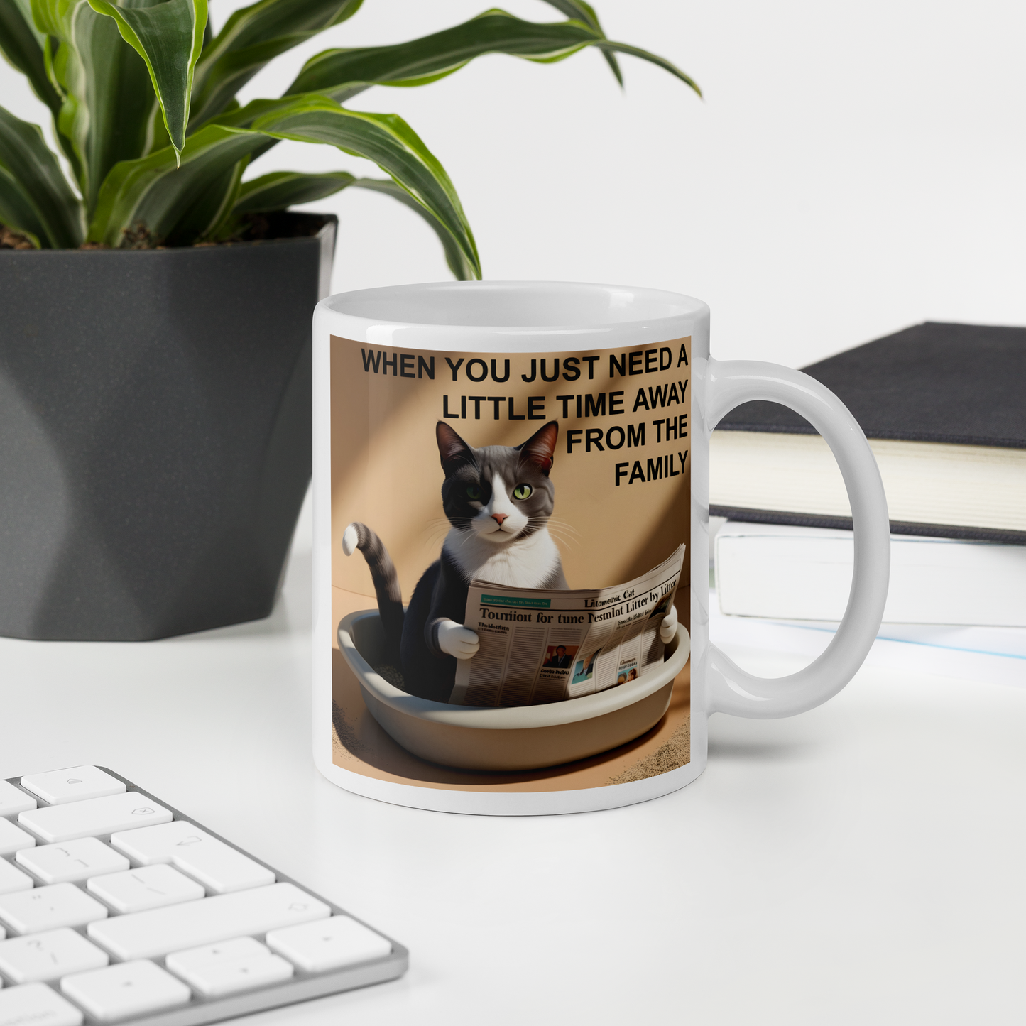 Mug with a cat design and text on a desk with a plant and books in the background - 11 oz