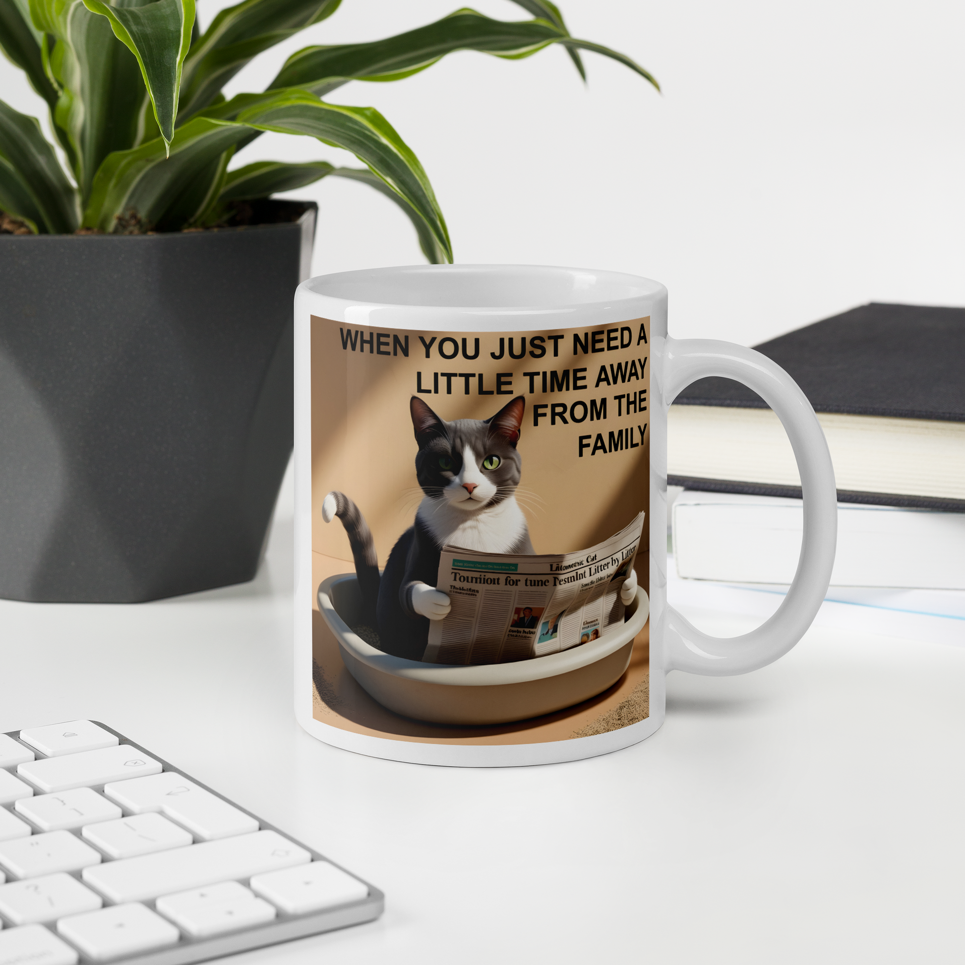 Mug with a cat design and text on a desk with a plant and books in the background - 11 oz