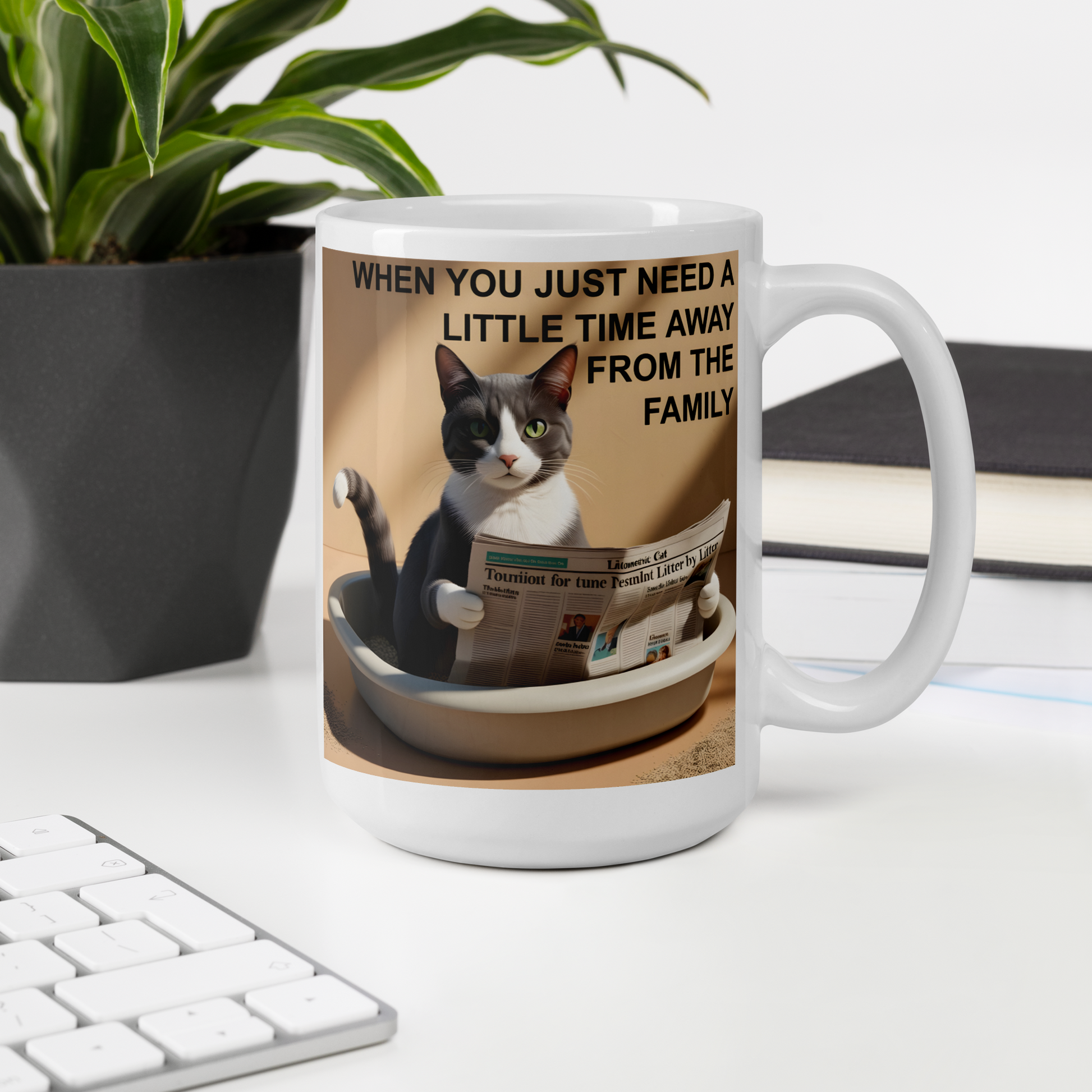Mug with a cat graphic and text on a desk with a plant and books in the background - 15 oz