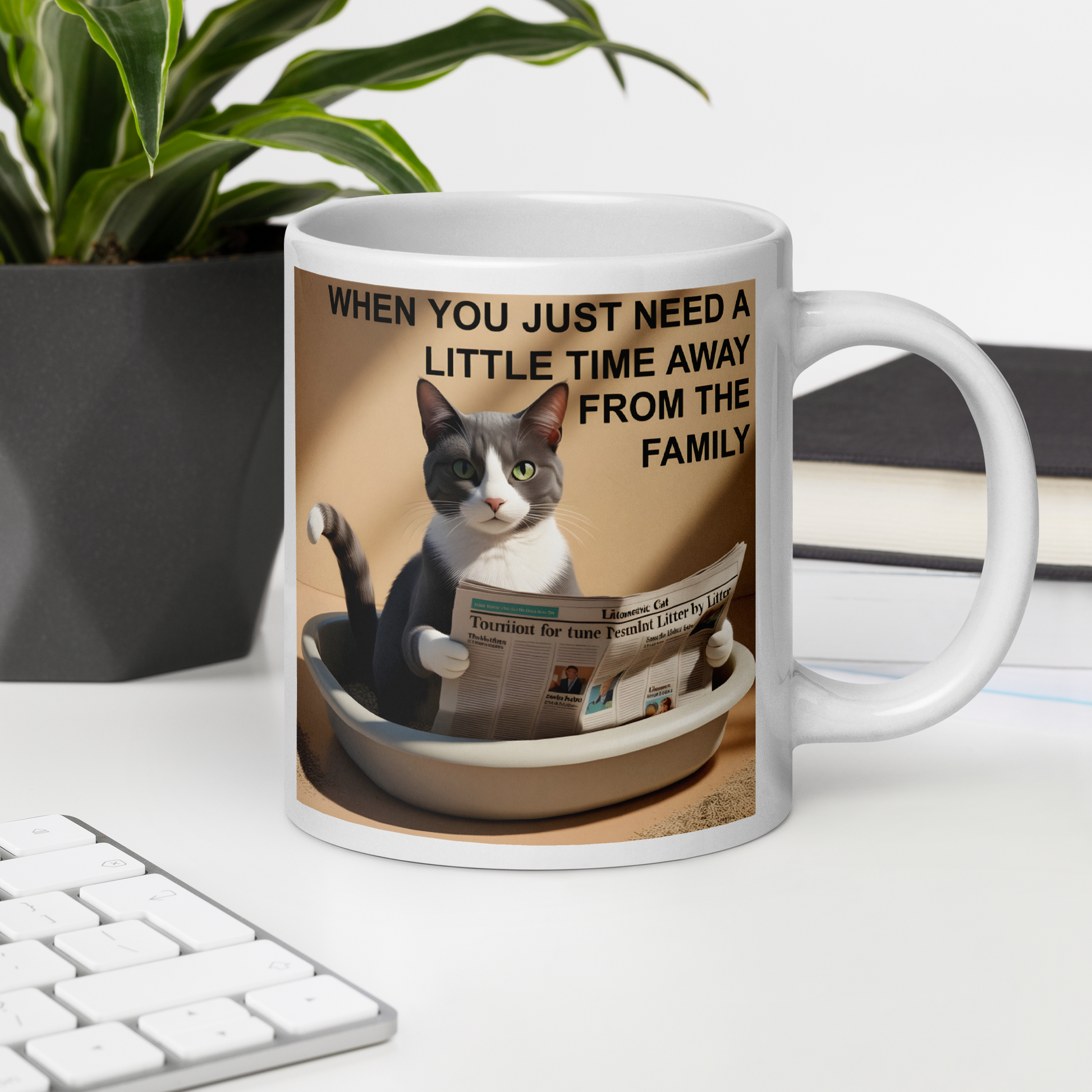 White mug with a cat graphic and text on a desk with a plant and books in the background - 20 oz